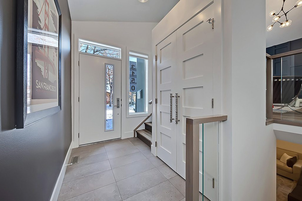 Foto di un corridoio design di medie dimensioni con una porta singola, una porta bianca, pareti bianche, pavimento con piastrelle in ceramica e pavimento grigio