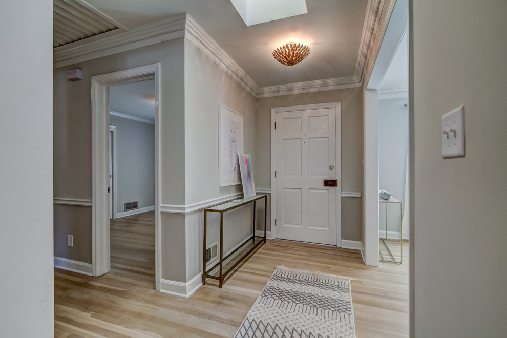 На фото: узкая прихожая среднего размера в стиле неоклассика (современная классика) с серыми стенами, светлым паркетным полом, одностворчатой входной дверью, белой входной дверью и коричневым полом