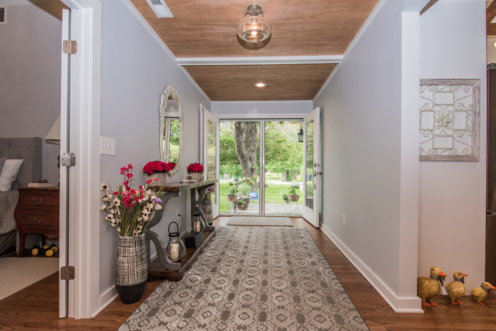 Entryway - large contemporary medium tone wood floor and brown floor entryway idea in Other with white walls and a white front door