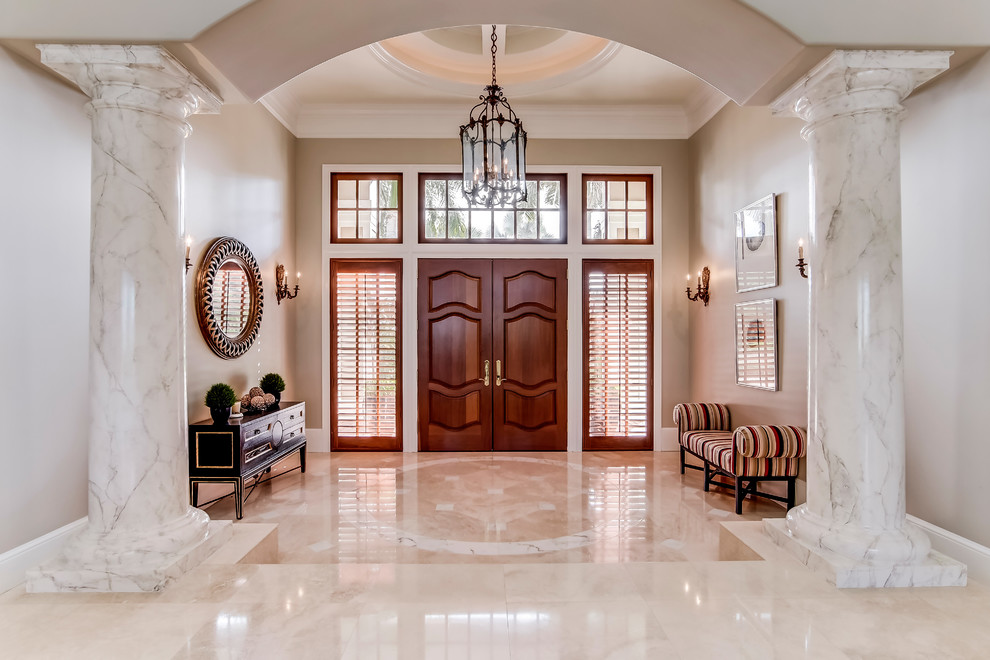 Ispirazione per un grande ingresso tradizionale con pareti beige, pavimento in marmo, una porta a due ante e una porta in legno scuro
