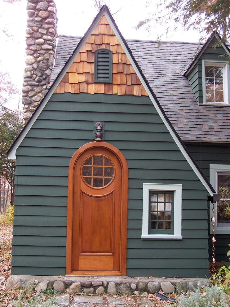 Cette image montre une entrée traditionnelle avec une porte simple et une porte en bois brun.