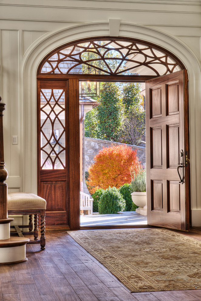 他の地域にある高級な広いトラディショナルスタイルのおしゃれな玄関ドア (白い壁、無垢フローリング、木目調のドア) の写真