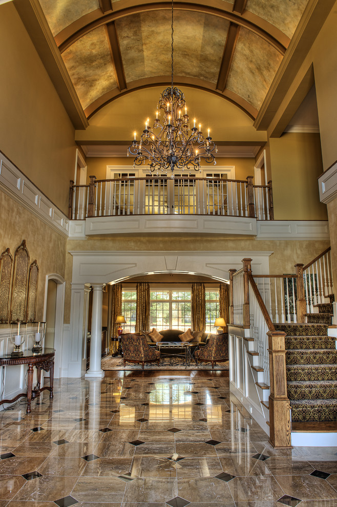 Example of a huge classic limestone floor foyer design in Other with yellow walls