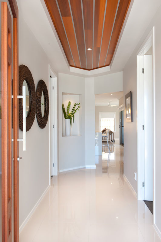 Réalisation d'une porte d'entrée minimaliste avec un sol en carrelage de porcelaine, une porte pivot et une porte en bois brun.