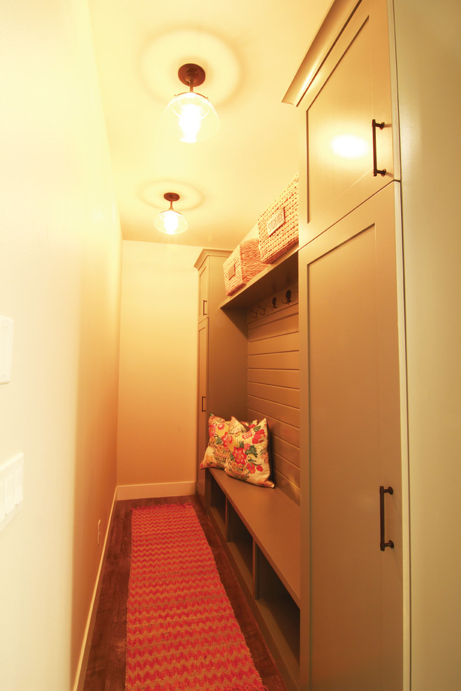 Small country boot room in Other with beige walls, laminate floors and brown floors.