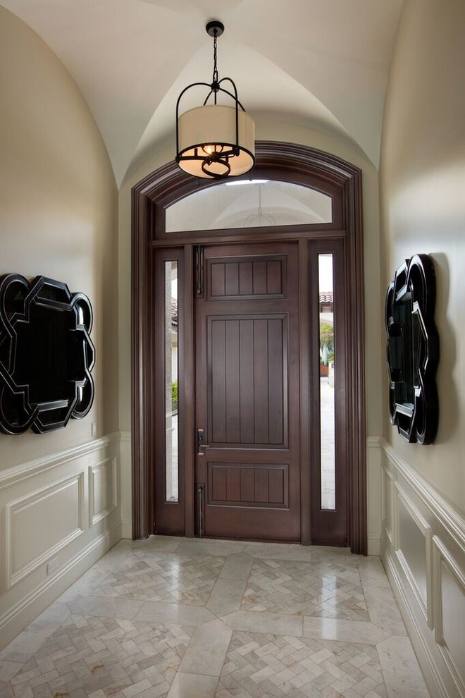 Idee per un corridoio chic di medie dimensioni con pareti beige, una porta singola, una porta in legno scuro, pavimento in marmo e pavimento grigio