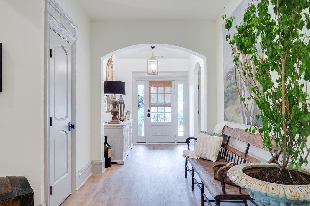 Foto de hall clásico de tamaño medio con paredes blancas, suelo de madera clara, puerta simple y puerta blanca