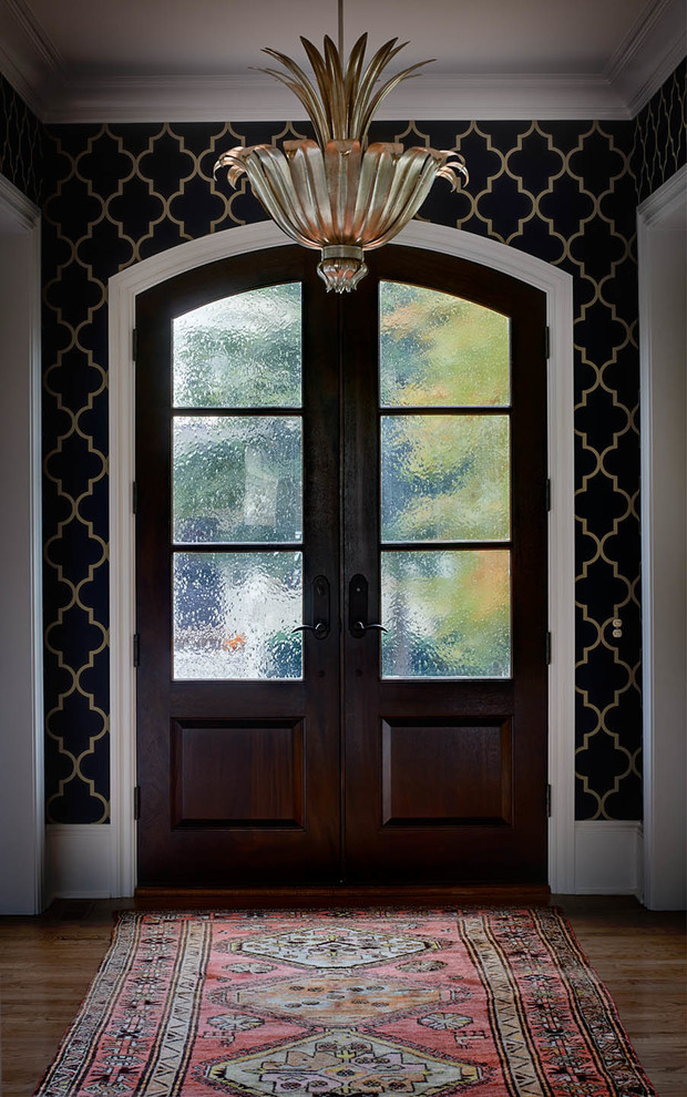 Example of a transitional light wood floor entryway design in Charlotte with a dark wood front door