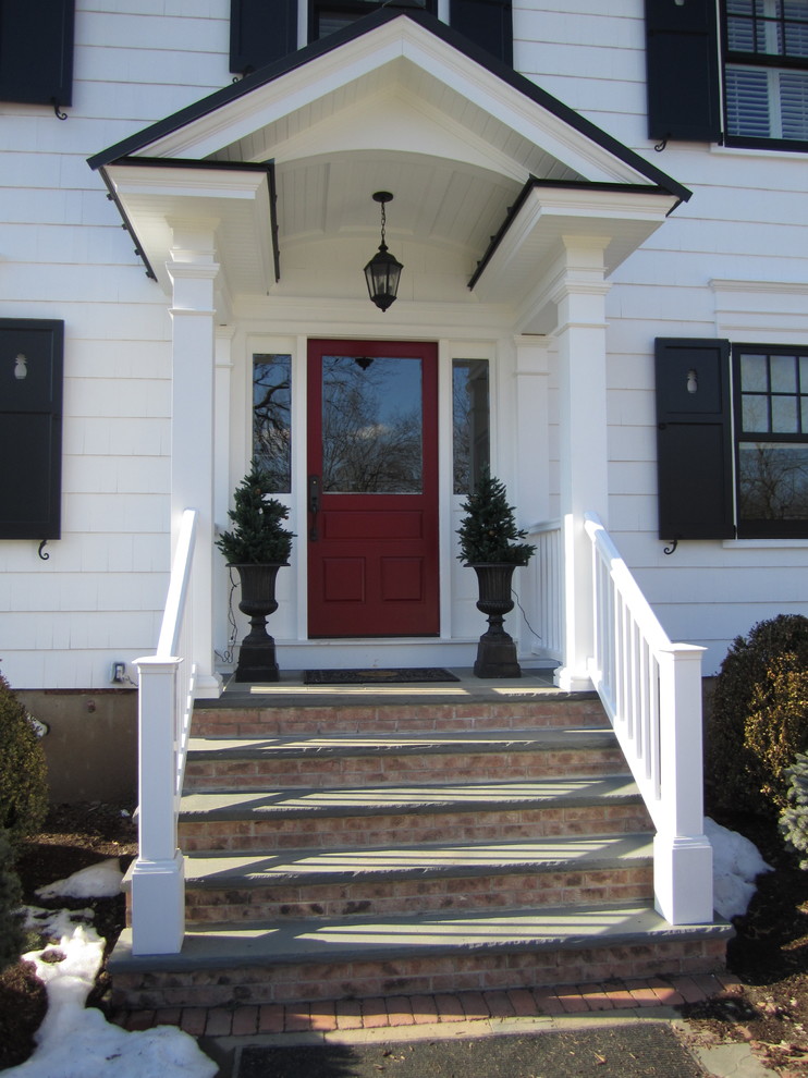 Ejemplo de puerta principal campestre de tamaño medio con paredes blancas, suelo de pizarra, puerta simple y puerta roja