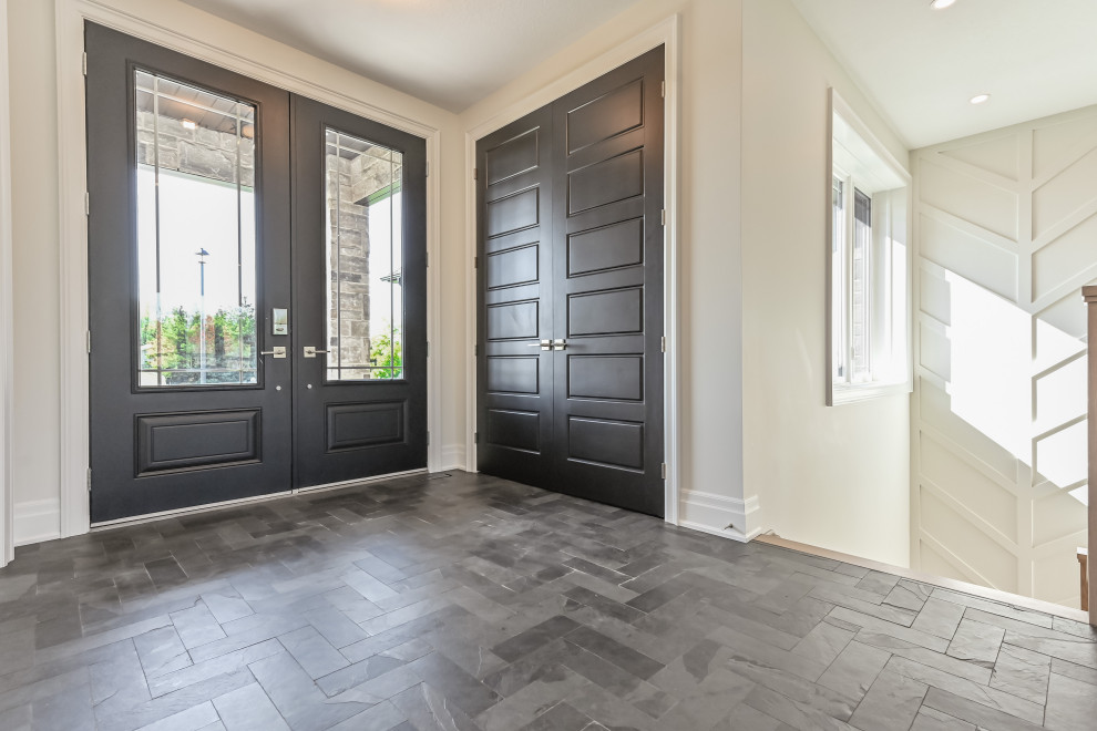 Small contemporary front door in Toronto with slate flooring and black floors.
