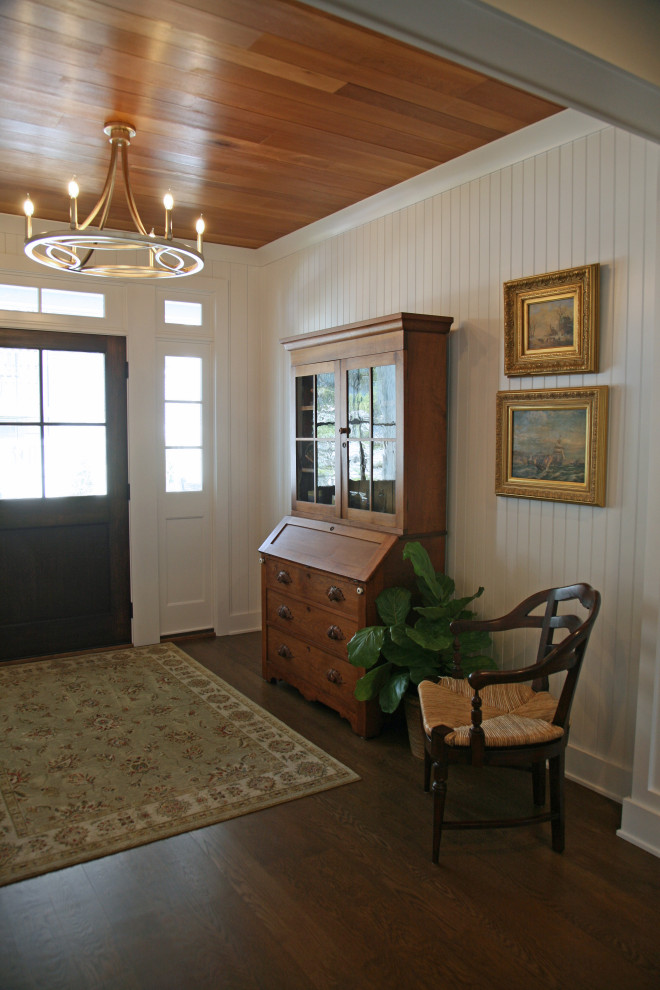 На фото: фойе среднего размера в морском стиле с белыми стенами, паркетным полом среднего тона, одностворчатой входной дверью, входной дверью из темного дерева, коричневым полом, деревянным потолком и деревянными стенами с