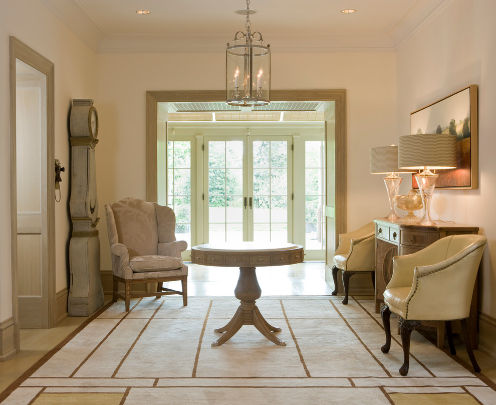 Inspiration for a traditional foyer in DC Metro with white walls, light hardwood flooring and a glass front door.