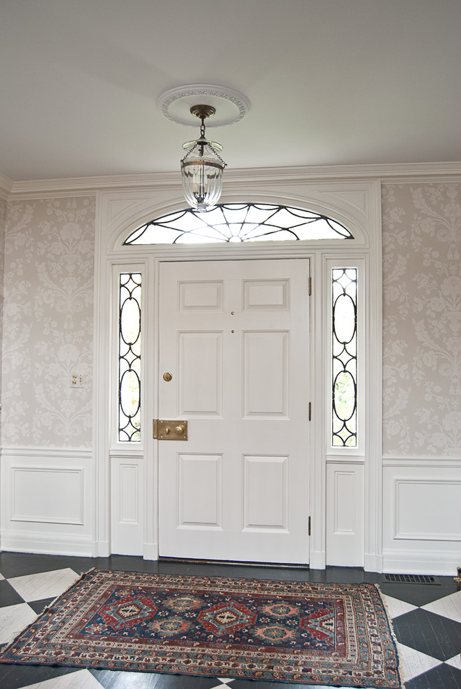 Inspiration pour un hall d'entrée traditionnel de taille moyenne avec parquet peint, une porte simple et une porte blanche.