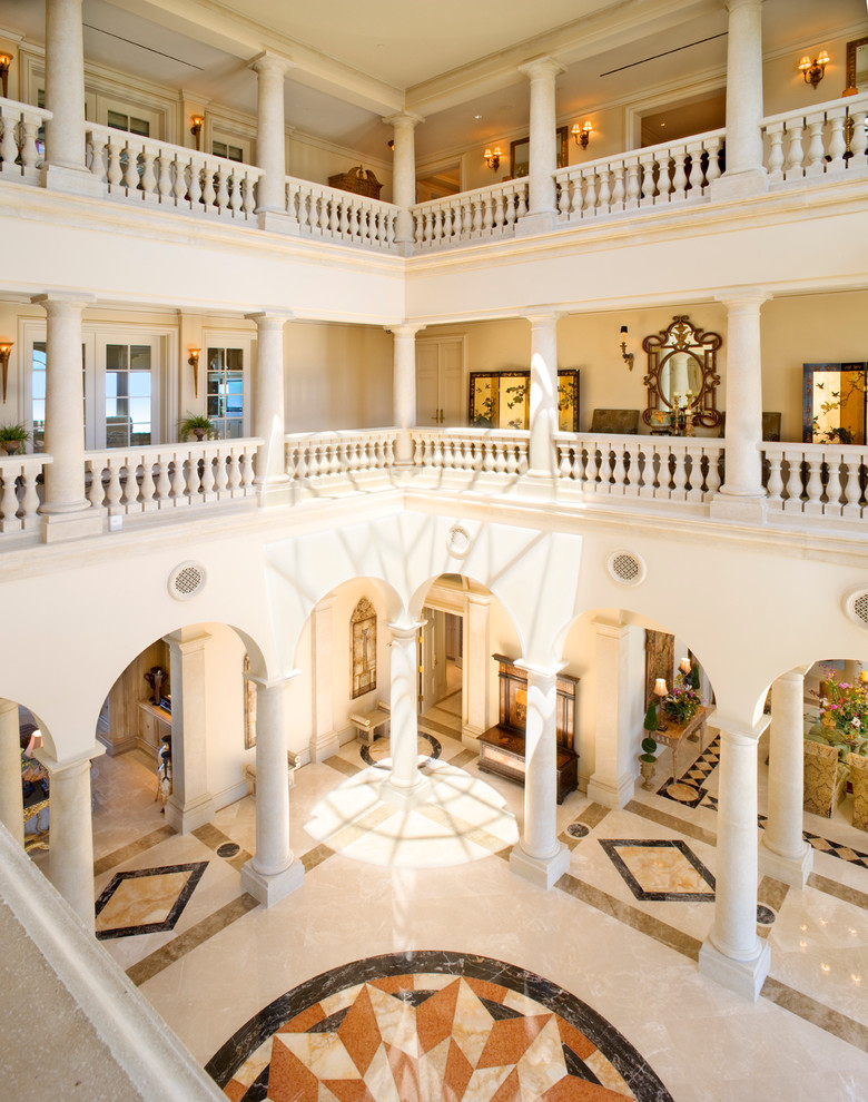 Aménagement d'un très grand hall d'entrée classique avec un mur beige, un sol en marbre et un sol beige.