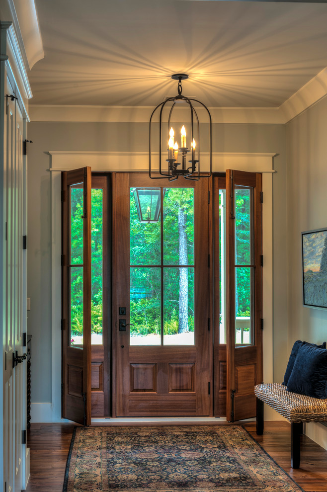 Пример оригинального дизайна: узкая прихожая среднего размера в классическом стиле с серыми стенами, паркетным полом среднего тона, одностворчатой входной дверью, входной дверью из дерева среднего тона и коричневым полом