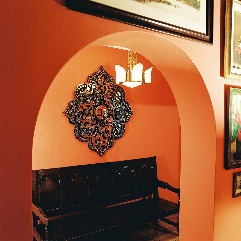 На фото: большая узкая прихожая в средиземноморском стиле с оранжевыми стенами, паркетным полом среднего тона и коричневым полом