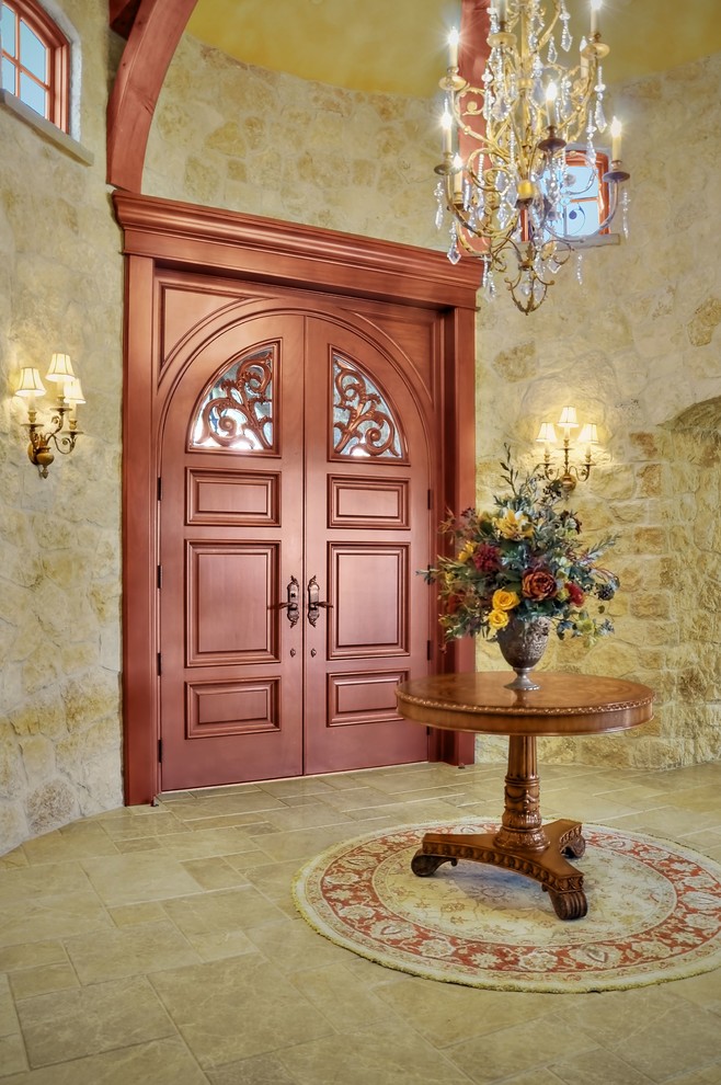 Пример оригинального дизайна: большая входная дверь в классическом стиле с двустворчатой входной дверью, бежевыми стенами, полом из известняка, входной дверью из дерева среднего тона и бежевым полом