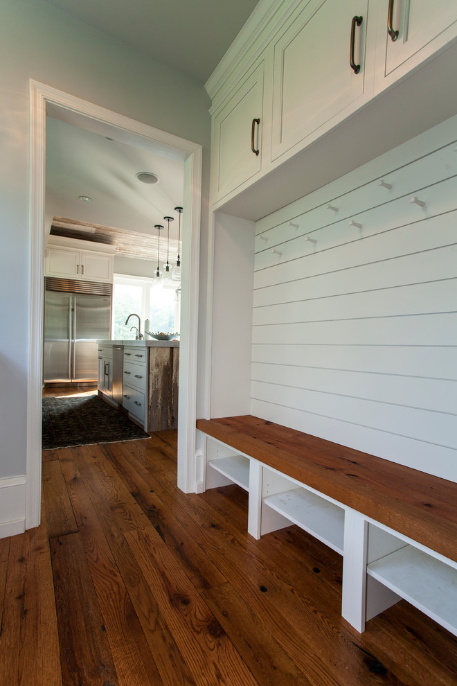 Inspiration for a mid-sized country medium tone wood floor mudroom remodel in Philadelphia with white walls
