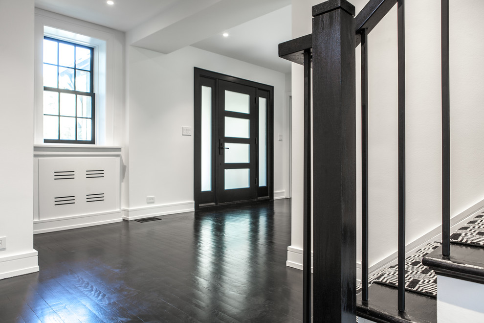 Ispirazione per un ingresso moderno di medie dimensioni con pareti bianche, parquet scuro, una porta nera, pavimento nero e una porta a pivot