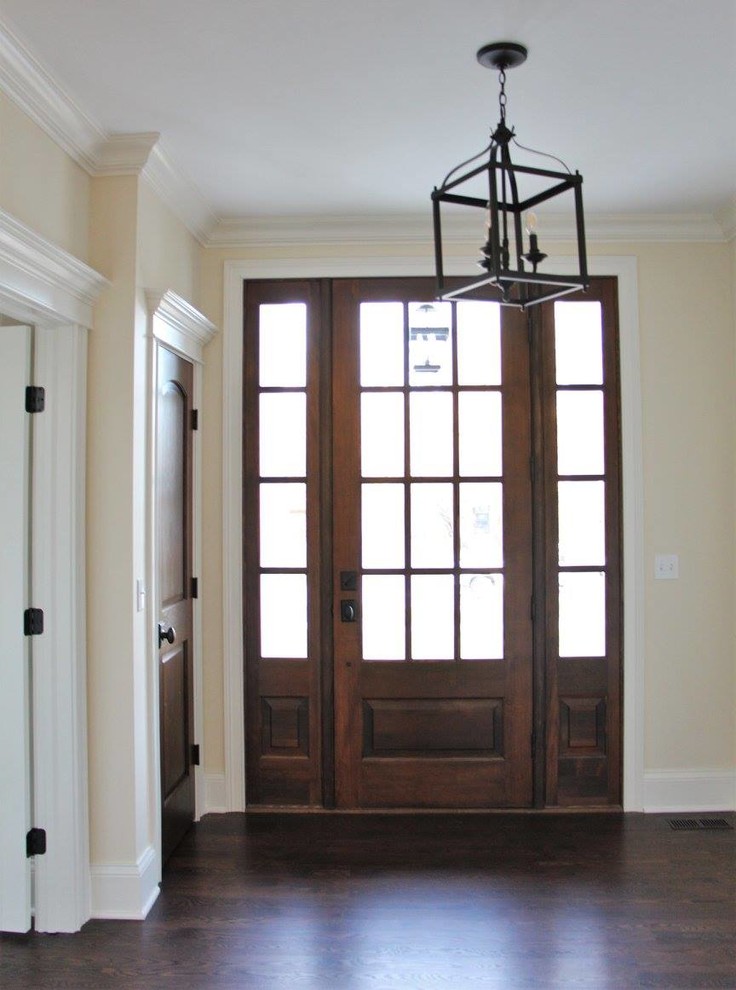 Mittelgroßes Klassisches Foyer mit beiger Wandfarbe, dunklem Holzboden, Einzeltür, dunkler Holzhaustür und braunem Boden in Chicago
