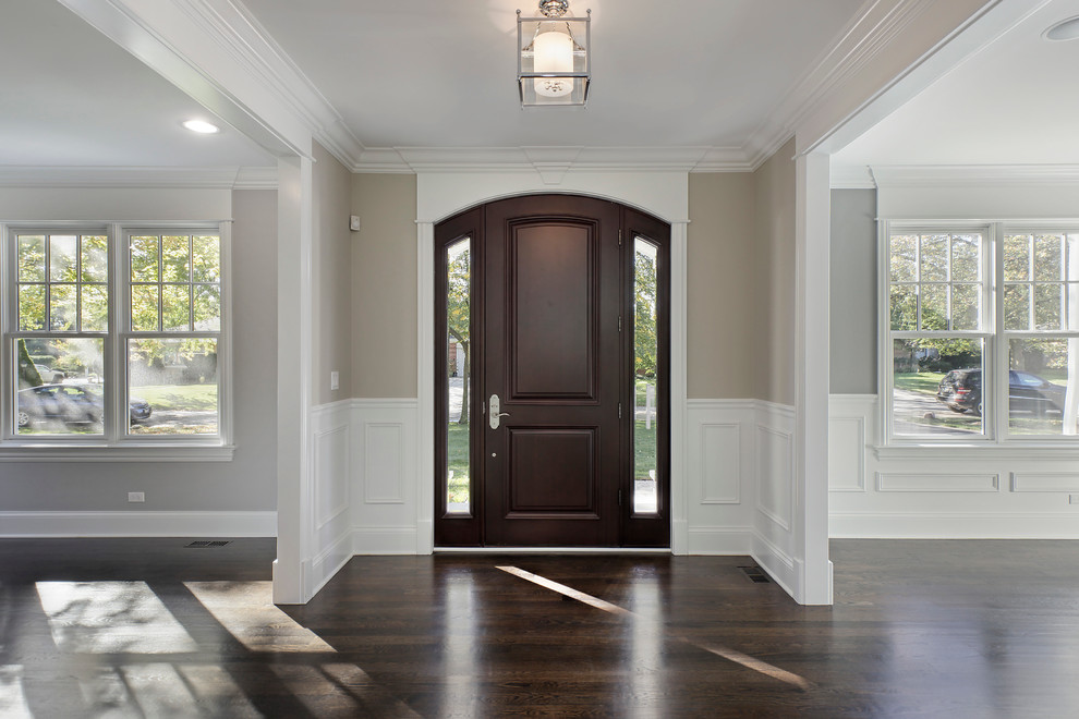 Design ideas for a large traditional foyer in Chicago with grey walls, dark hardwood flooring, a single front door and a dark wood front door.