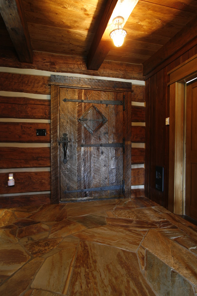 Immagine di una grande porta d'ingresso rustica con pareti marroni, una porta a pivot e una porta in legno scuro