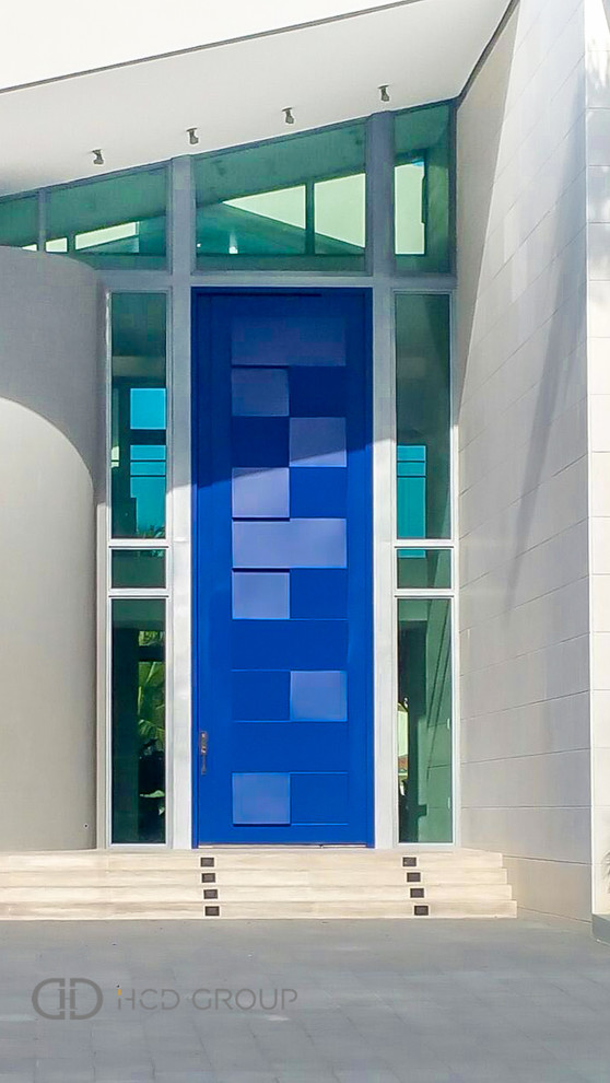 Exemple d'une grande porte d'entrée moderne avec un mur blanc, un sol en calcaire, une porte pivot et une porte bleue.