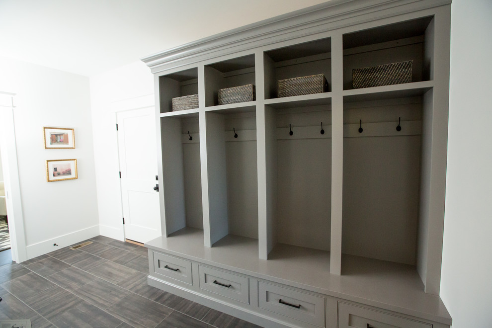 Inspiration for a large traditional boot room in Other with white walls, porcelain flooring and grey floors.