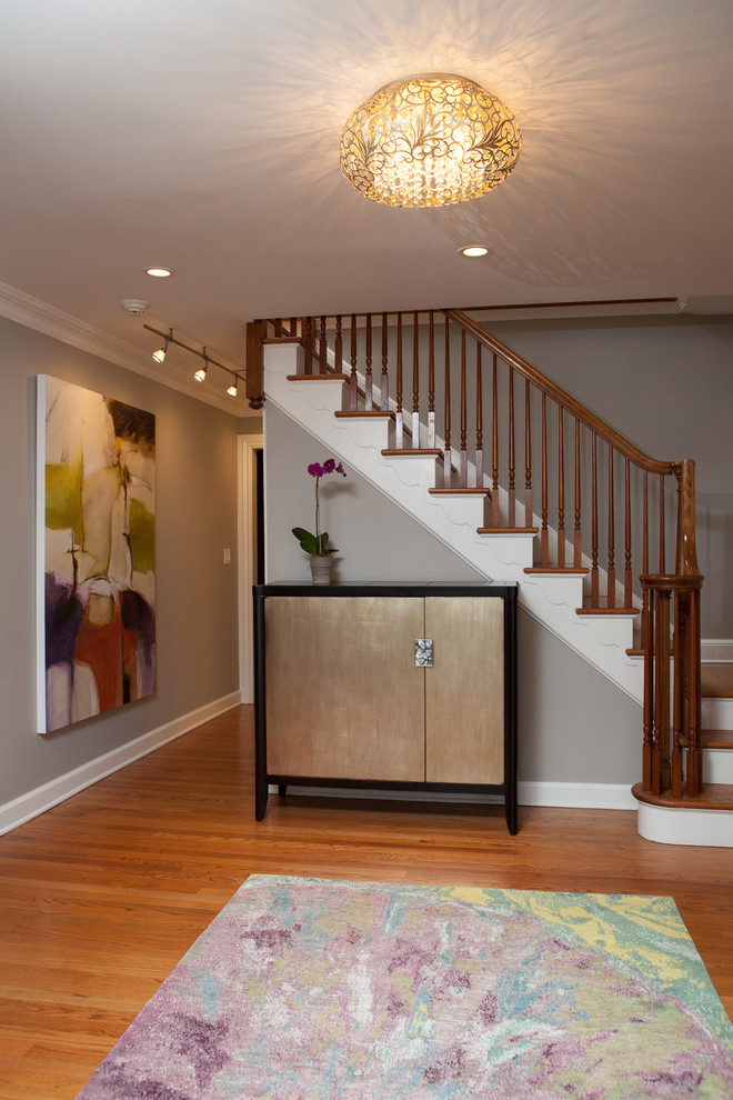 Traditional foyer in Chicago with grey walls, light hardwood flooring and brown floors.