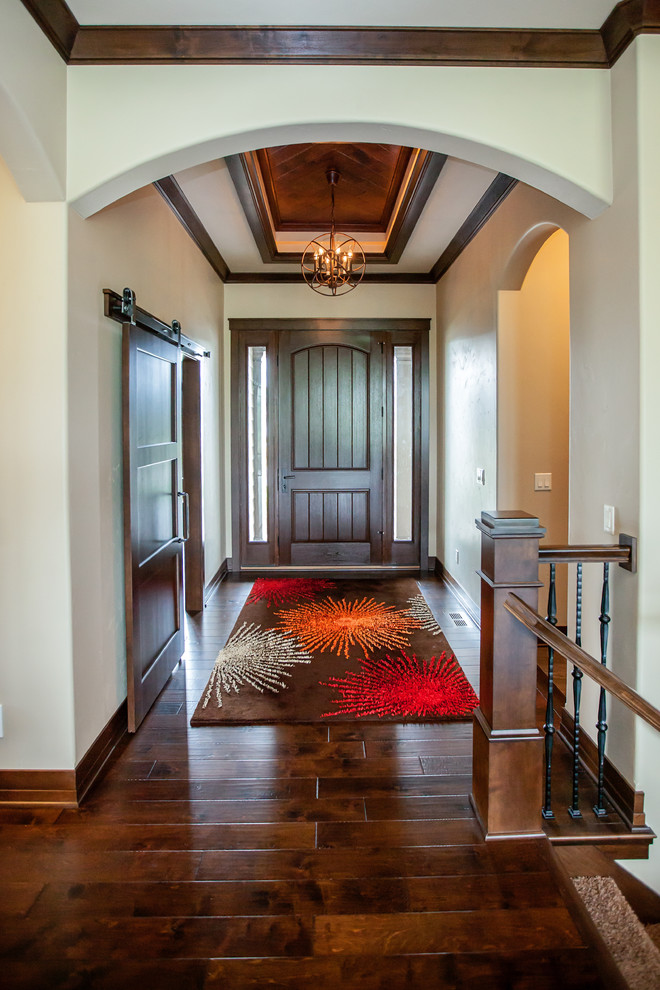 Klassischer Eingang mit Korridor, beiger Wandfarbe, dunklem Holzboden, Einzeltür und dunkler Holzhaustür in Milwaukee
