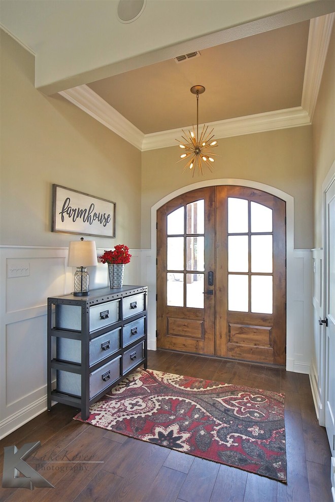 Ejemplo de hall tradicional renovado de tamaño medio con paredes beige, suelo de madera oscura, puerta doble, puerta de vidrio y suelo marrón