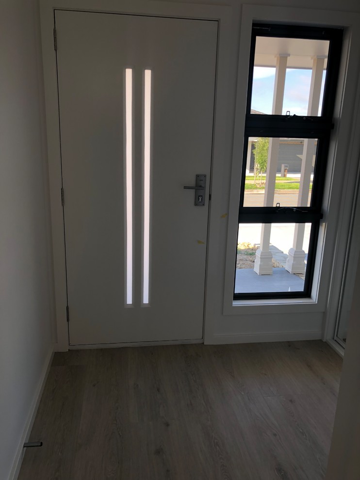 Diseño de puerta principal moderna de tamaño medio con paredes blancas, suelo de madera clara, puerta simple, puerta de vidrio y suelo beige