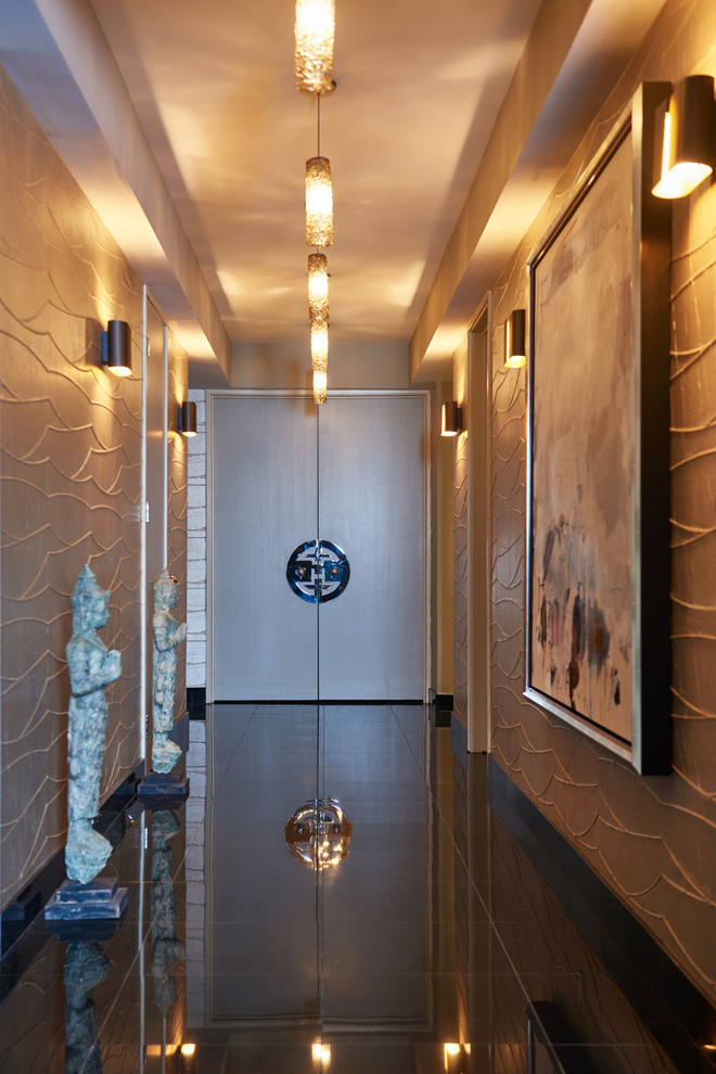 Cette image montre une entrée design de taille moyenne avec mur métallisé, sol en granite, une porte double, un sol marron et un couloir.
