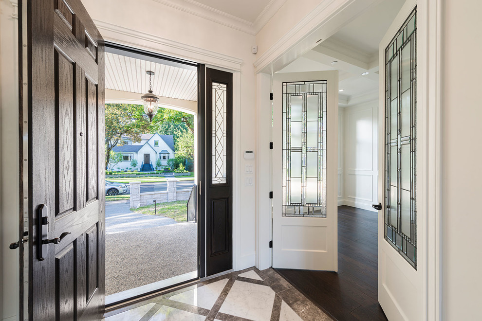 Источник вдохновения для домашнего уюта: большое фойе в классическом стиле с белыми стенами, темным паркетным полом, коричневой входной дверью и одностворчатой входной дверью