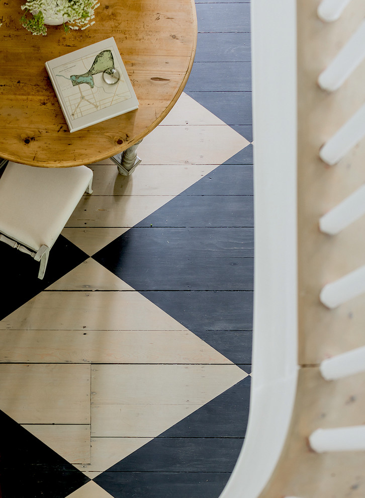 Transitional painted wood floor entryway photo with white walls and a black front door