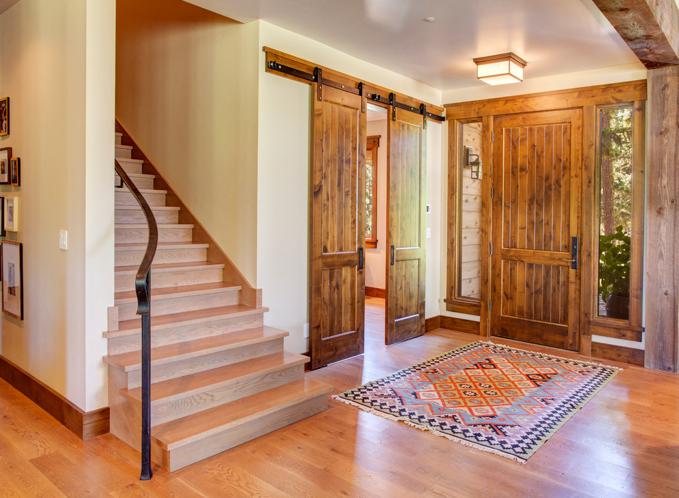 Rustikales Foyer mit braunem Holzboden, Einzeltür, hellbrauner Holzhaustür und weißer Wandfarbe in Seattle