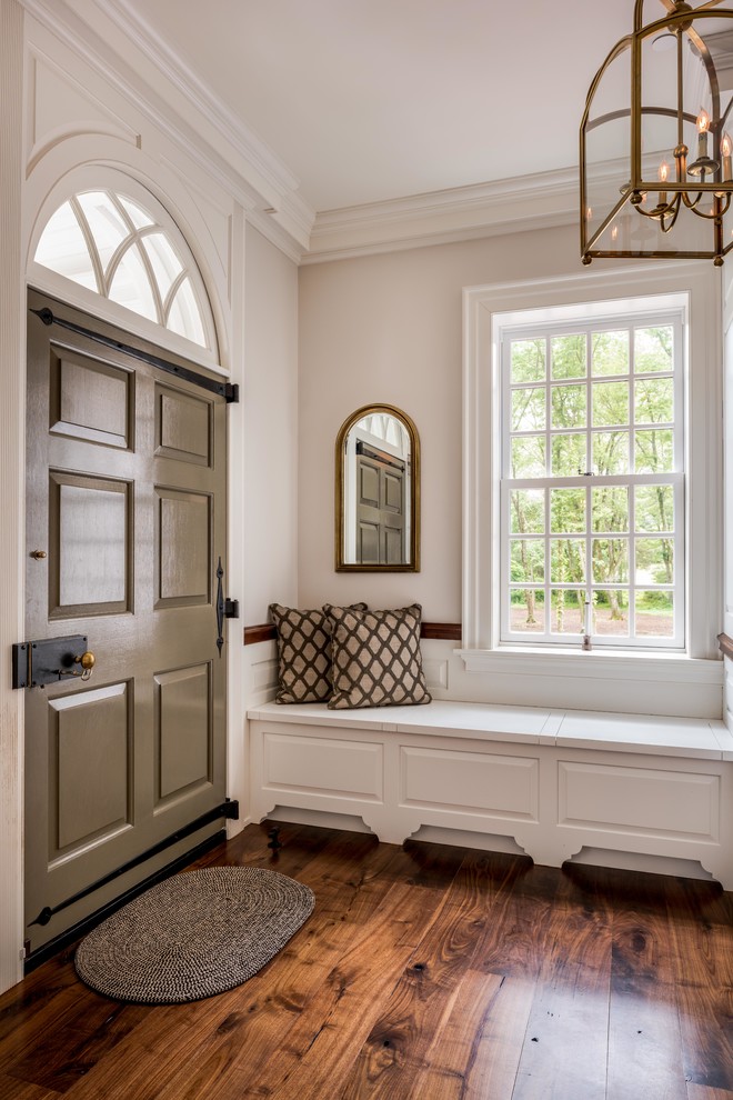 Imagen de distribuidor clásico con paredes blancas, suelo de madera en tonos medios, puerta simple y puerta gris
