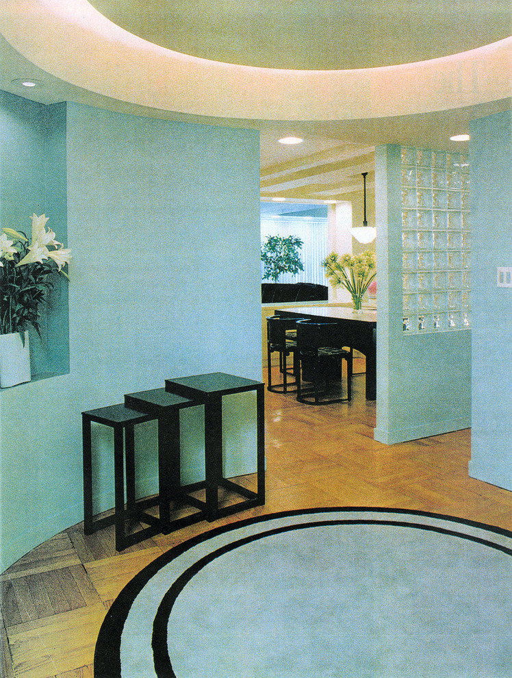 Foto di un ampio ingresso minimalista con pareti verdi e pavimento in legno massello medio