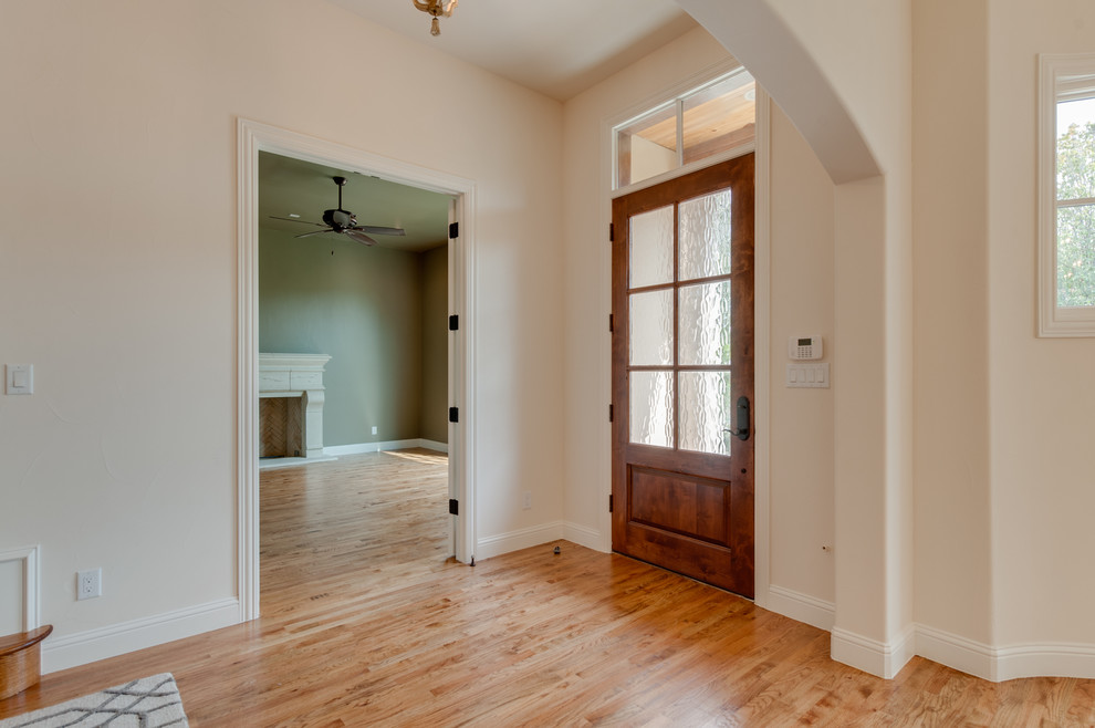 Inspiration for a mid-sized mediterranean light wood floor entryway remodel in Dallas with beige walls and a medium wood front door