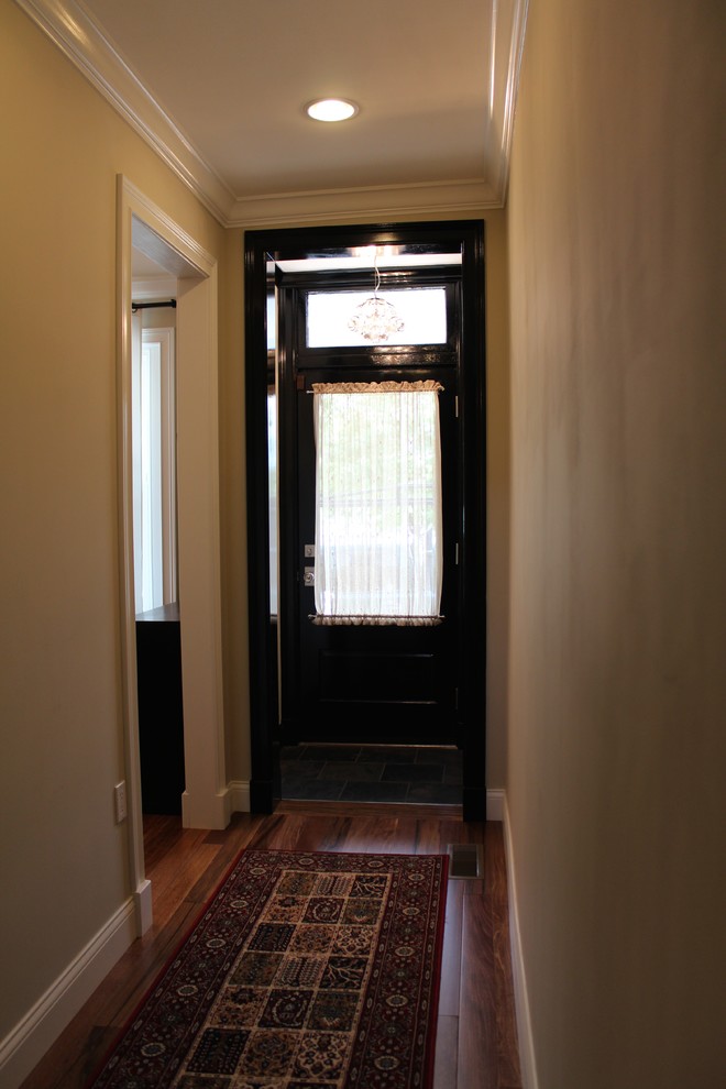 Small eclectic medium tone wood floor entryway photo in Philadelphia with a black front door and beige walls