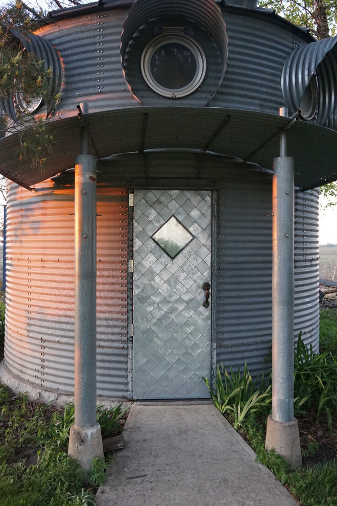 Industriell inredning av en liten ingång och ytterdörr, med betonggolv, en enkeldörr och metalldörr