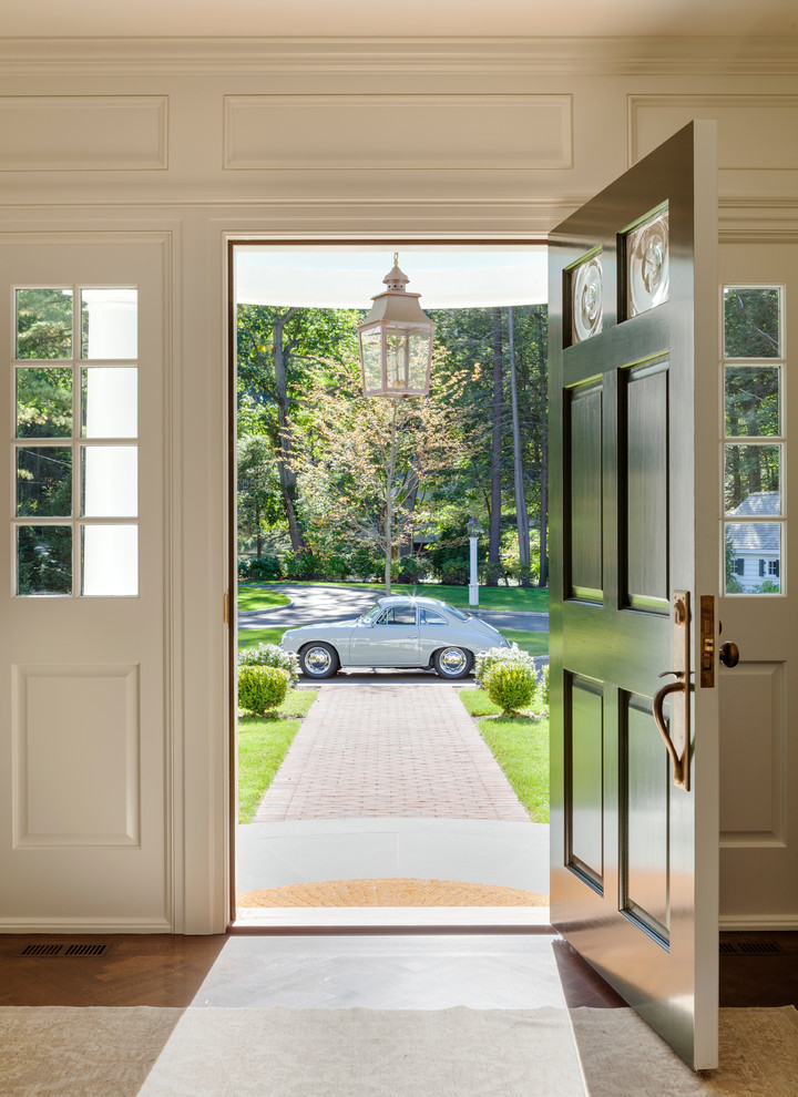 Стильный дизайн: входная дверь в классическом стиле с белыми стенами, темным паркетным полом, поворотной входной дверью и зеленой входной дверью - последний тренд