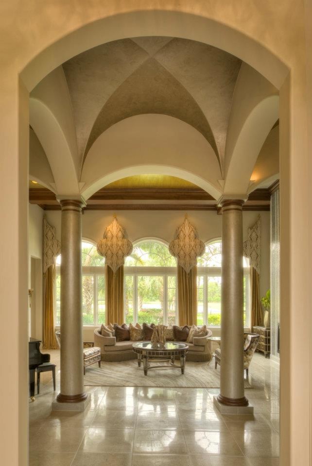 Réalisation d'un très grand hall d'entrée tradition avec un mur beige, un sol en marbre, une porte double et une porte en bois foncé.