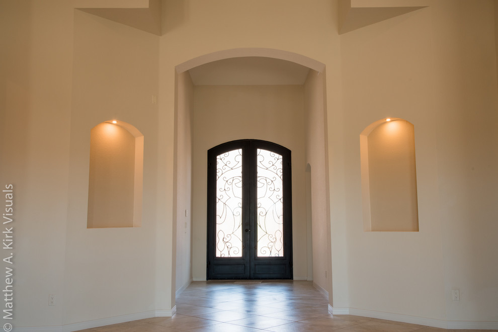 Idee per un piccolo ingresso mediterraneo con pareti beige, pavimento in gres porcellanato, una porta a due ante, una porta nera e pavimento beige