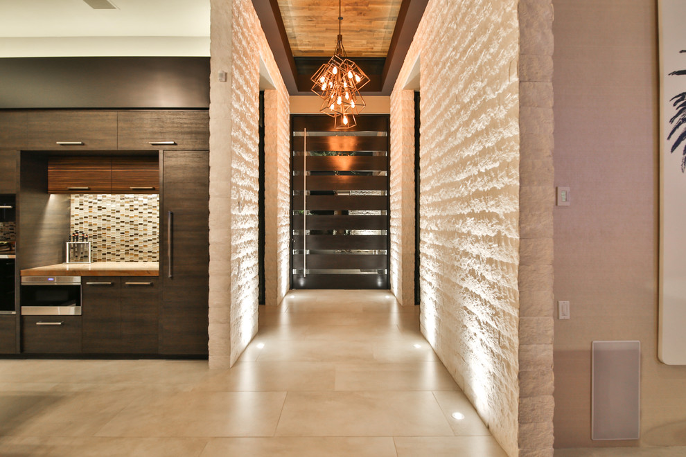 Example of a large trendy porcelain tile and beige floor entryway design in Los Angeles with beige walls and a dark wood front door