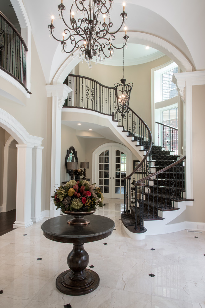 Example of a huge classic marble floor and white floor entryway design in Other with beige walls and a dark wood front door