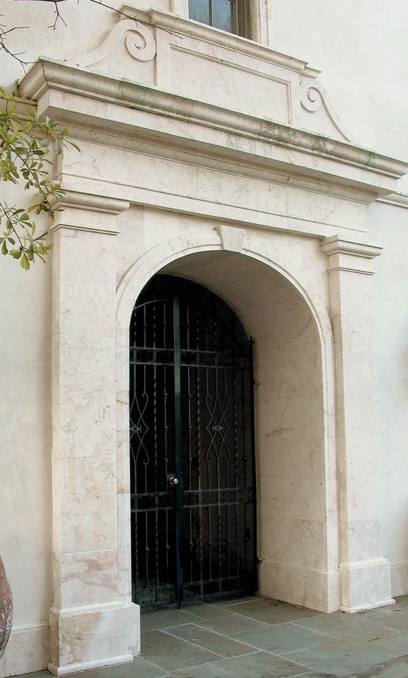 Immagine di una grande porta d'ingresso mediterranea con una porta a due ante e una porta nera