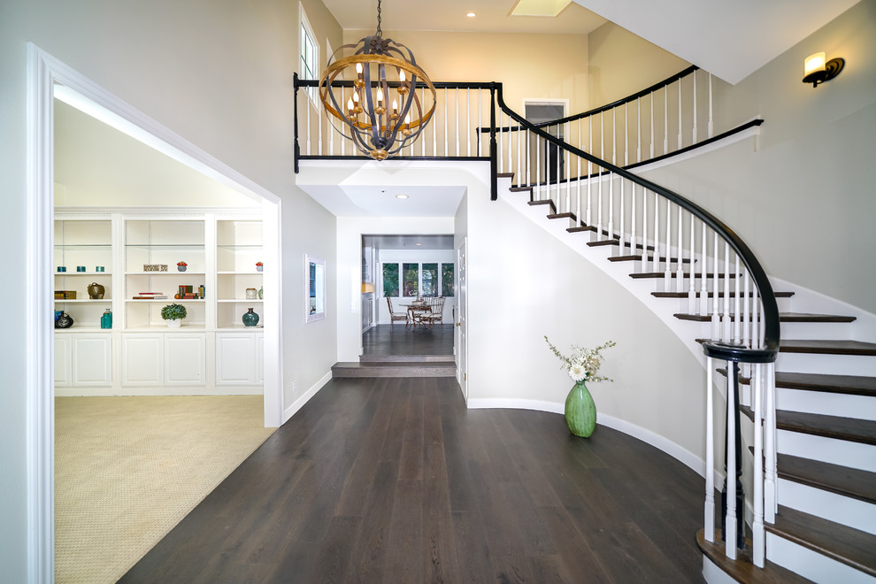 This is an example of an expansive classic foyer in San Francisco with grey walls, dark hardwood flooring, a red front door and brown floors.
