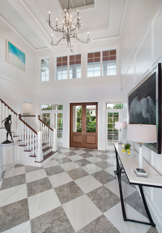 Photo of a large world-inspired foyer in Miami with ceramic flooring, a double front door, a medium wood front door and feature lighting.