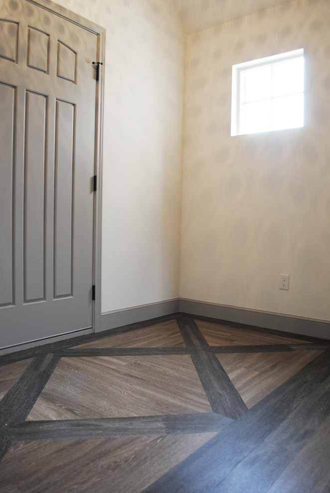 Aménagement d'une porte d'entrée éclectique de taille moyenne avec un mur beige, un sol en vinyl et une porte grise.